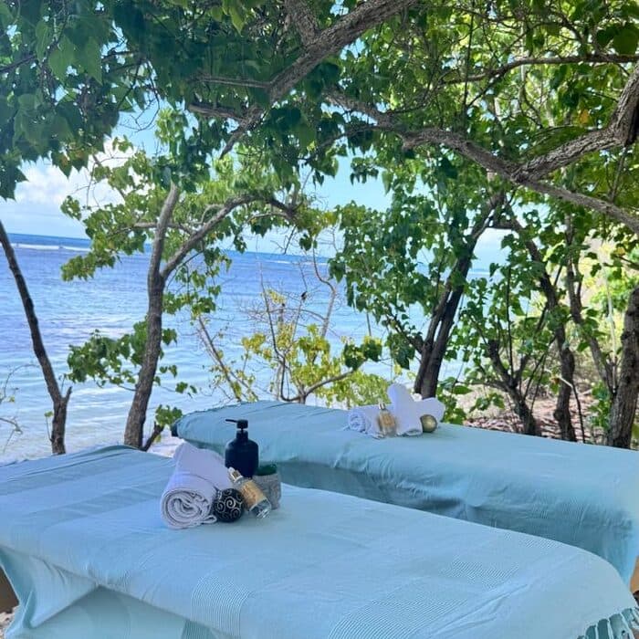 Tables de massage turquoise face à l'océan en Guadeloupe